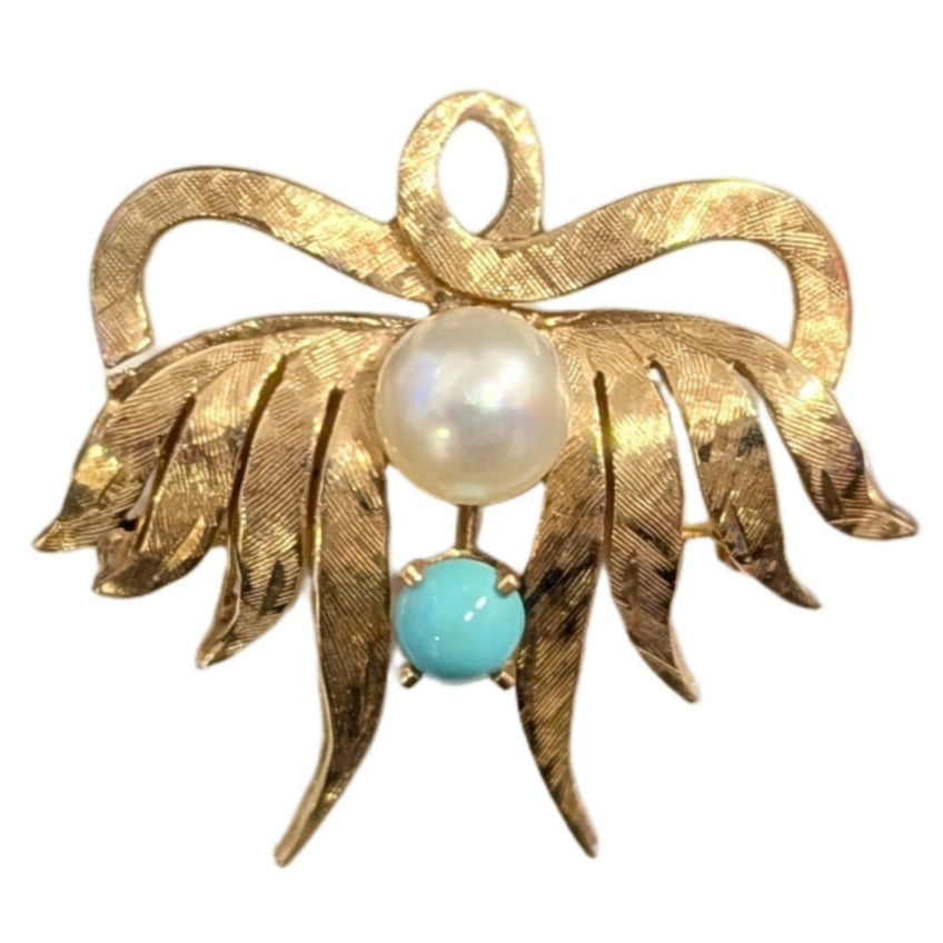 Gold brooch with pearl and turquoise stone on a white background