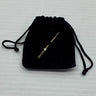 A vintage brooch pin with a genuine diamond centerpiece, attached to a black fabric bag.
