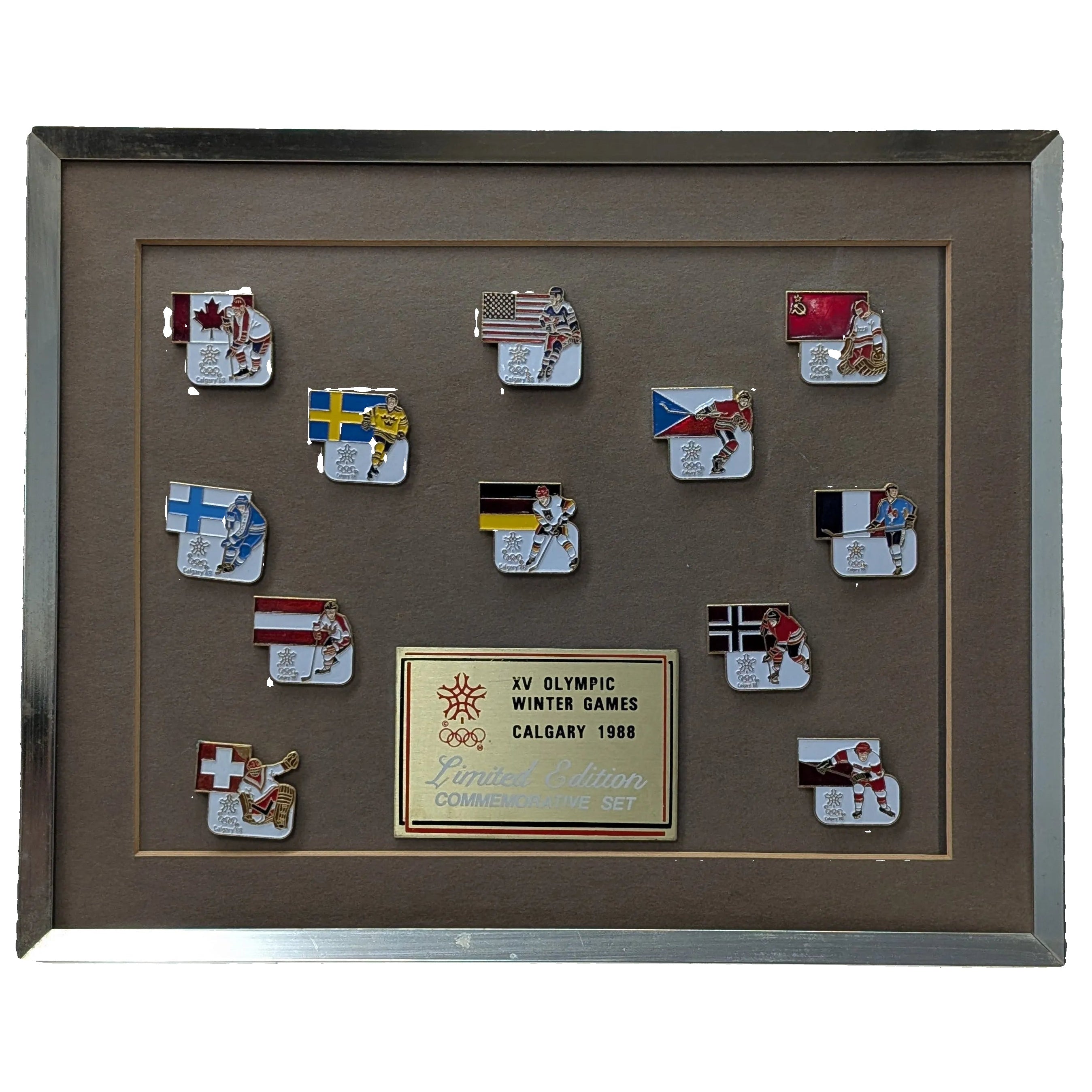 Framed collection of Olympic pins from the Calgary 1988 Winter Games on a white background