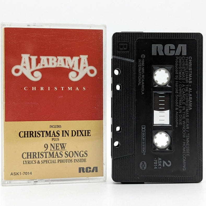 A vintage RCA cassette tape and its paper sleeve for 'Alabama Christmas' by Alabama, displayed on a white surface.