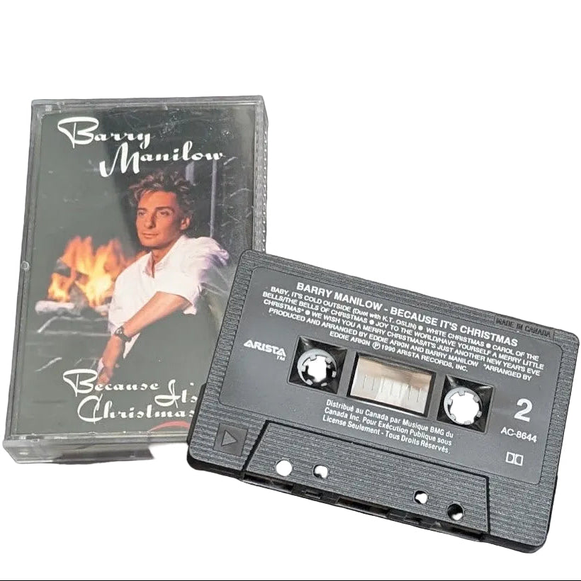 A vintage cassette tape and its plastic jewel case for Barry Manilow's 'Because It's Christmas' album, displayed on a white surface.