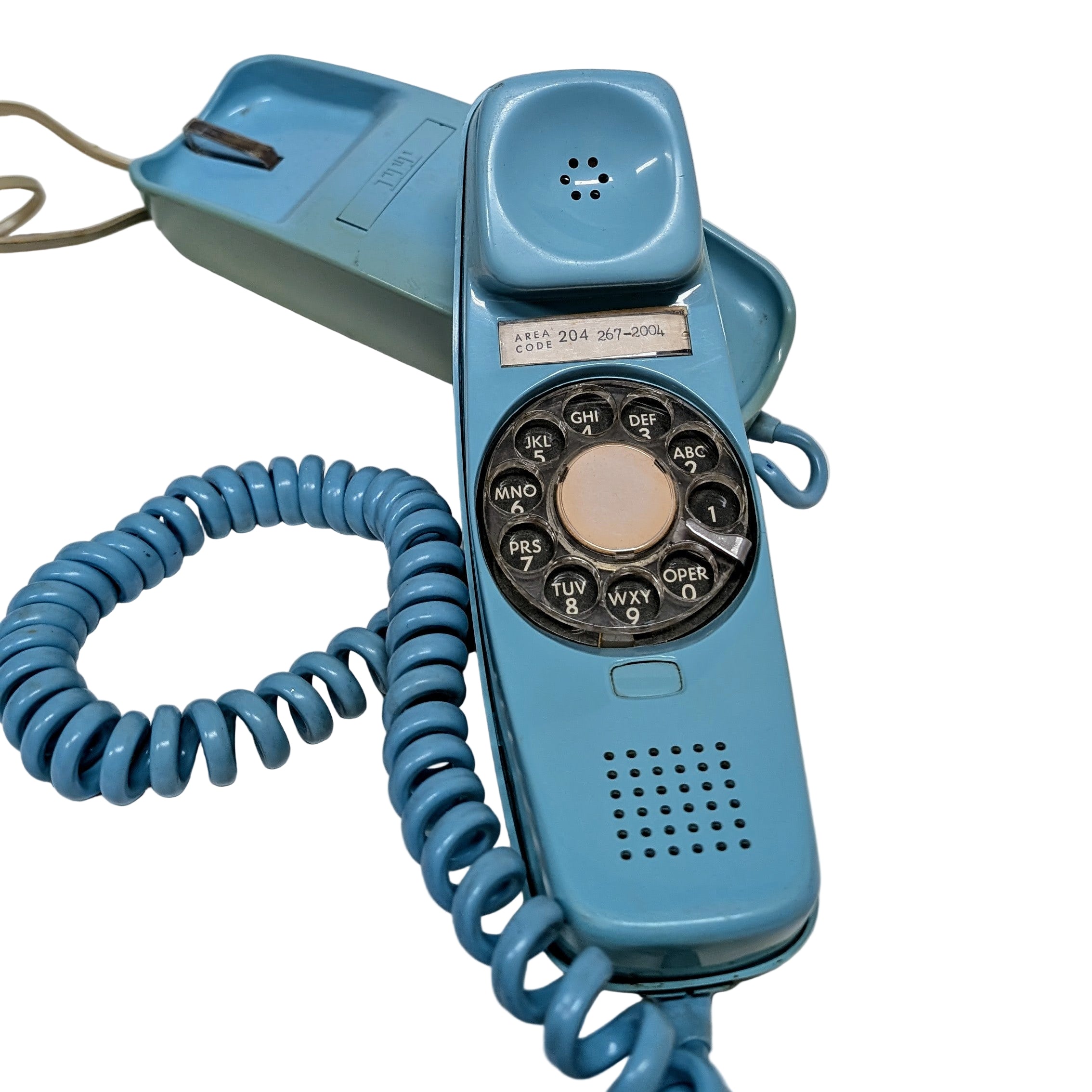 A vintage blue ITT dial desk phone with a coiled cord, showing the front view with the dial pad and speaker.