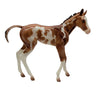 Model horse with brown and white pattern on a white background