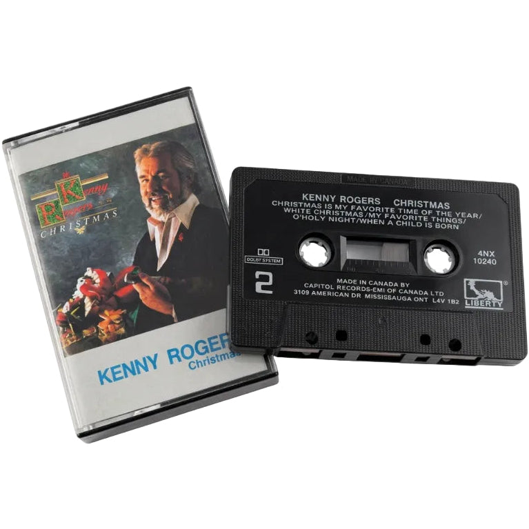 A vintage cassette tape and its paper sleeve for Kenny Rogers' Christmas album 'Holiday Night When a Child Is Born', placed on a white surface.