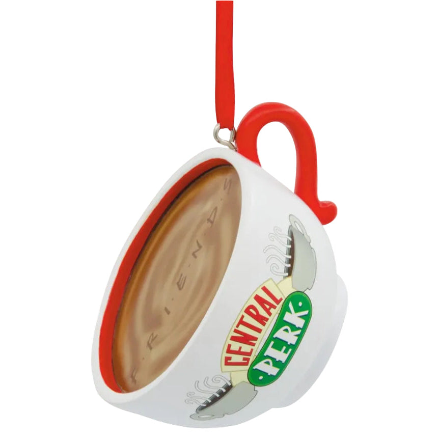 A Friends-themed Christmas ornament shaped like a teacup, with a red hanging loop, white exterior, brown interior, and the Friends logo printed on the side.