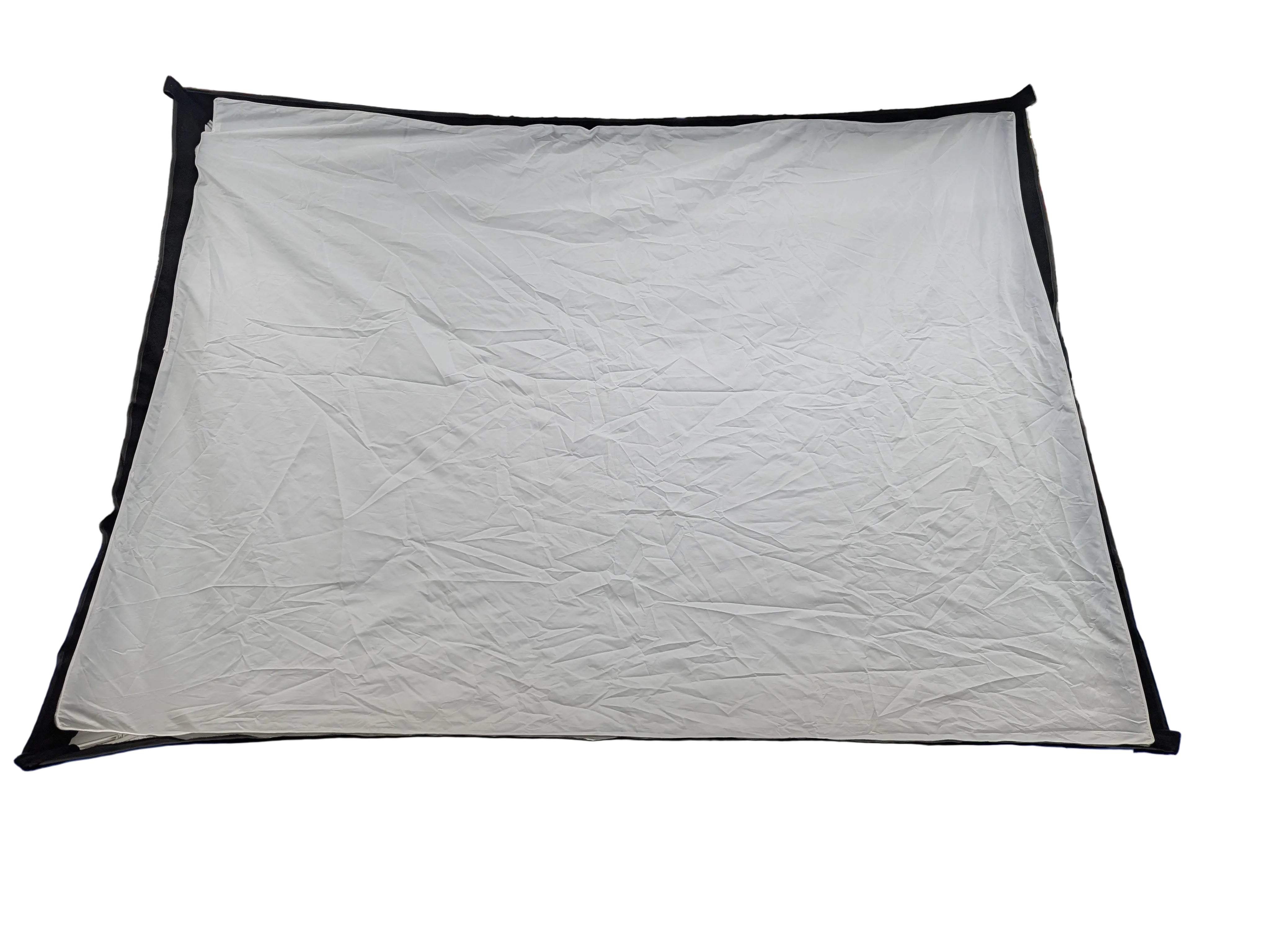 A large white fabric backdrop or sheet with black trim