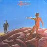 The album cover of Rush - Hemispheres, featuring a surreal scene of a nude figure standing on pinkish-purple hills under a blue sky, with a suited man in a hat and cane on the left. The band name 'Rush' is written in red at the top.