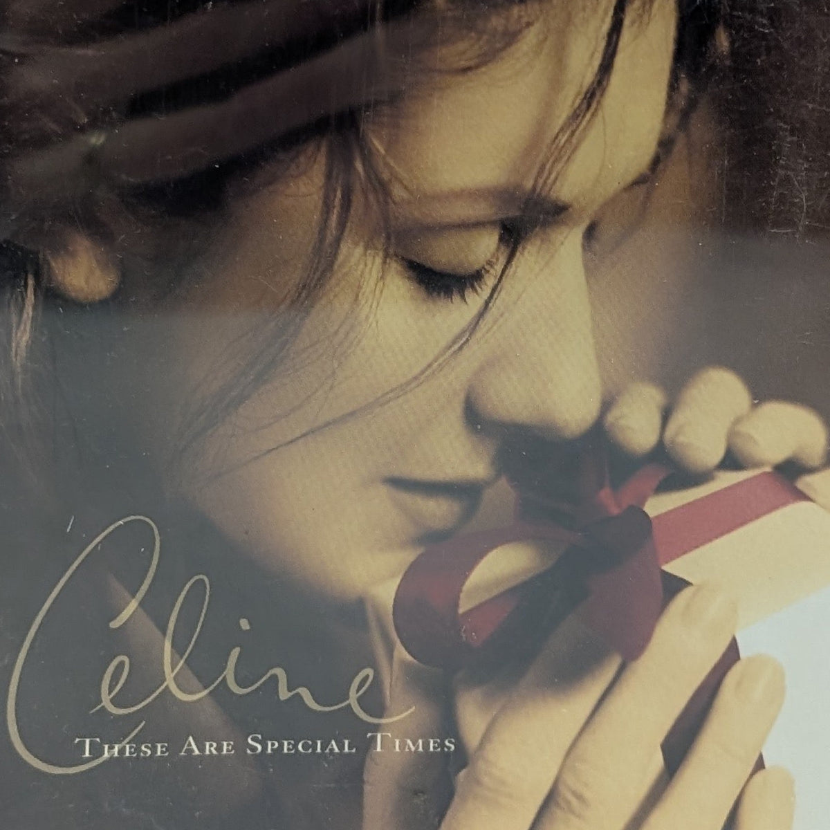 Celine 'These Are Special Times' CD album cover, featuring a sepia-toned close-up portrait of a woman holding a small gift box with a red ribbon. The album is housed in a clear jewel case.