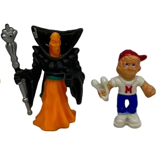 A set of three vintage Mighty Max toy figures on a white background, including a character with a slingshot and red hat, and two others without a slingshot.