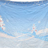 A light blue fabric wall tapestry featuring a winter Christmas scene with two decorated trees, snow, and falling snowflakes, displayed against a white background.