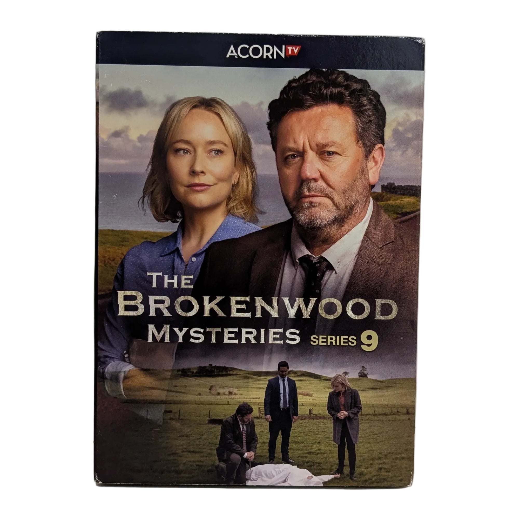The Brokenwood Mysteries Series 9 DVD box set by Acorn TV, standing upright on a white surface against a white wall.