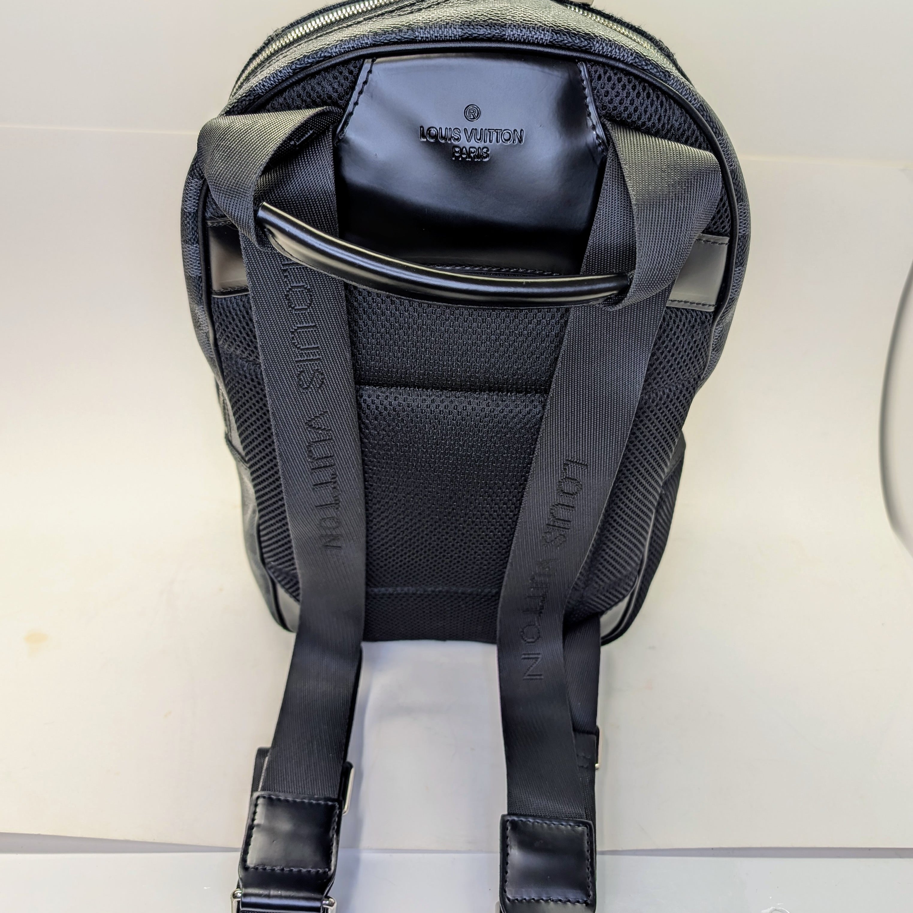Black backpack with visible branding on a light gray background