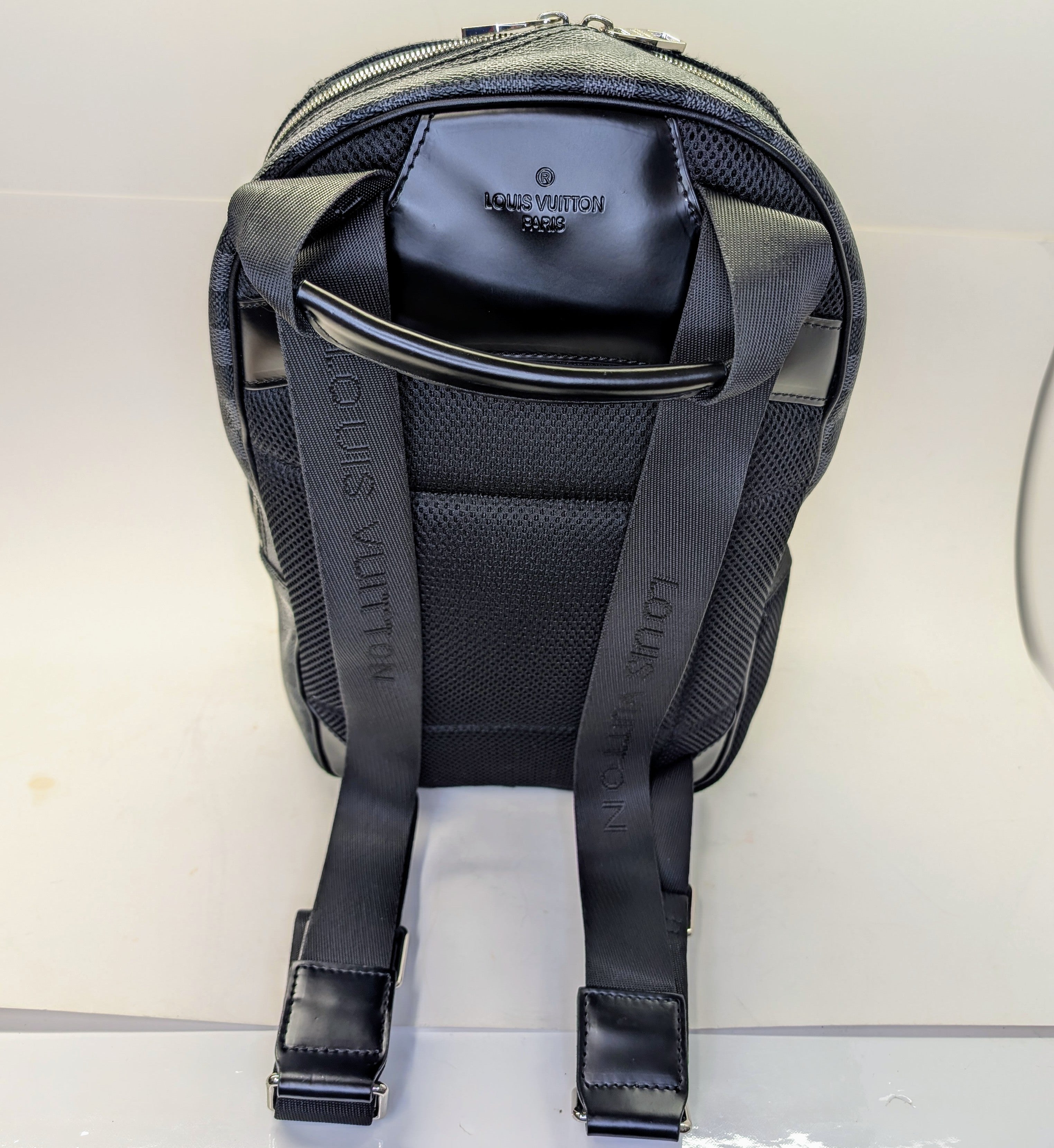 Black backpack with visible branding on a light gray background